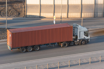 Wall Mural - Truck on a trip with a trailer and a metal container, shipping. Aerial top view.