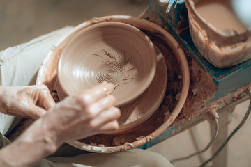 Close up of male arms with stick over ceramic plate