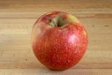 Fototapeta  - Single isolated red apple on a wooden board