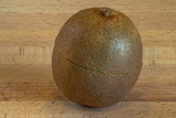 Fototapeta  - Single isolated kiwi fruit on a wooden board