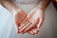 Bride Holding Gold Christian Crests In The Hands