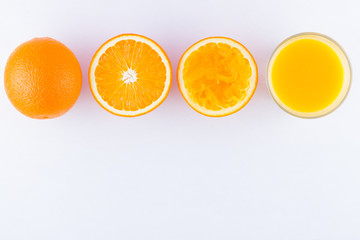 Wall Mural - Orange fruits with juice, concept. Orange juice and halves of oranges on white background. Citrus for making juice. Whole and squeezed oranges and glass of juice