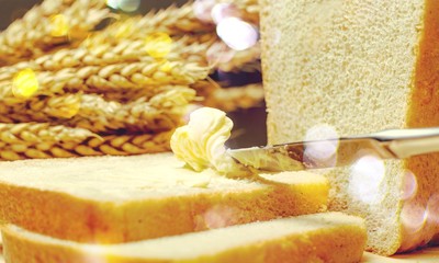 Sticker - Slices of bread with butter on wheat background