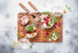 Beet or beetroot salad with fresh arugula, soft cheese and walnuts, trendy salad jar, piece on a fork, gray kitchen table background, copy space, top view