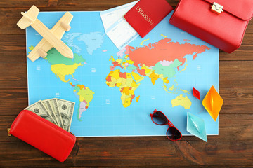 Sticker - World map with money, passport, tickets and female accessories on wooden table. Travel concept