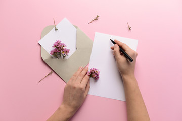 Female hands with empty invitation on color background