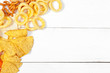Mix of snacks : pretzels , crackers , chips  and nachos on the table
