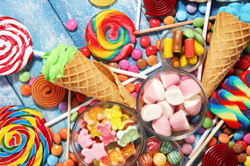 Wall Mural - candies with jelly and sugar. colorful array of different childs sweets and treats on blue