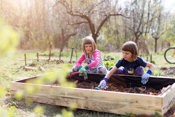 Two young girls gardening in urban community garden