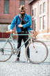 © rh2010 - Lifestyle portrait of a bearded hipster dressed stylishly with hat and jacket standing with retro bicycle on the urban background