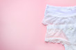 Set of white sexy lace women's panties on pink background. Top view. Close up.