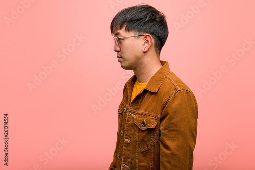Fotomural Young chinese man wearing a jacket on the side looking to front
