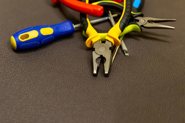 set of hand tools specialist in repairing electrical equipment close-up on a neutral gray background