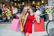 © veles_studio - Attractive girls in shopping mall with bags