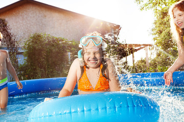 Canvas Print - Happy kids playing in blue water of swimming pool