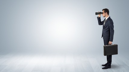 Wall Mural - businessman looking forward with binoculars in an empty space