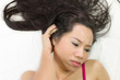 © Nutt - Closeup portrait of moody asian women  lying on ground with black long hair. acting upset , unhappy,