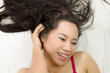 © Nutt - Closeup portrait of happy asian women  lying on ground with black long hair. acting smile, fun,