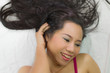 © Nutt - Closeup portrait of happy asian women  lying on ground with black long hair. acting smile, fun,