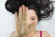 © Nutt - moody asian women  lying on ground with black long hair. acting upset , unhappy, and showing stop gesture
