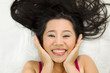 © Nutt - Closeup portrait of happy asian women  lying on ground with black long hair. acting smile, fun,
