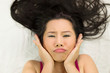 © Nutt - Closeup portrait of moody asian women  lying on ground with black long hair. acting upset , unhappy,
