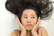 © Nutt - Closeup portrait of moody asian women  lying on ground with black long hair. acting upset , unhappy,