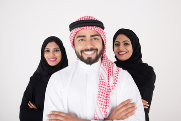 Canvas Print - Two arab females with one male smiling and standing on white background