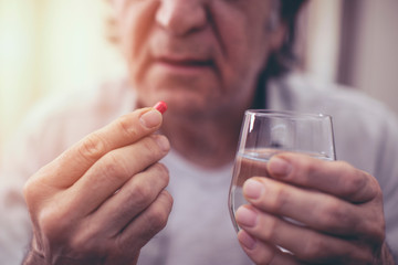 Old man taking a pill