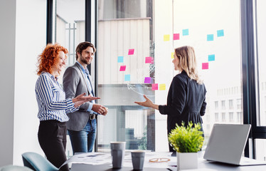 A group of young business people in an office, brainstorming.