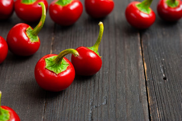 Wall Mural - cherry peppers on old black wooden table background