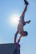 © qunica.com - Parkour guy exercising handstand on pyramid in skatepark