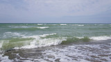 Fototapeta Morze - Summer day sea turquoise waves hit the shore. Sandy coast of the ocean.