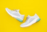 Fototapeta  - Pair of trendy sport sneakers on yellow background. Top view with copy space.