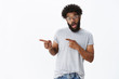 © Cookie Studio - Awesome copy space right here. Portrait of thrilled and cool mature african american guy with curly hair and beard open mouth in excitement as pointing left with amazement and surprise