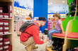 © Alinsa - Cute little girl and her father choosing clothes in the shop.