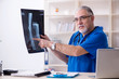© Elnur - White bearded old doctor radiologist working in clinic