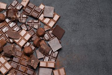 Wall Mural - Dark or milk organic chocolate pieces, cocoa powder and truffle candies on dark concrete backgound