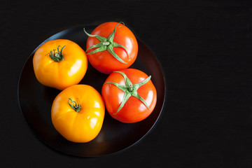 Two red tomatoes and two yellow tomatoes