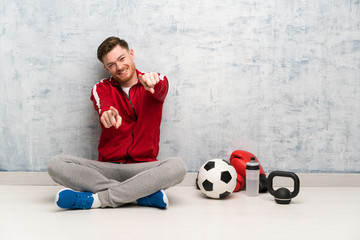 Redhead sport man points finger at you while smiling