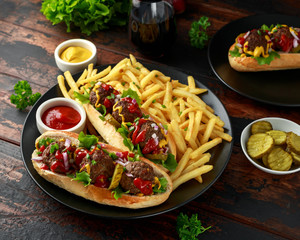 Wall Mural - Meat balls hotdogs with french potato fries, chips, crinkle cut gherkins, ketchup and mustard. fast food