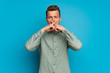 © luismolinero - Blonde man over isolated blue wall showing a sign of silence gesture