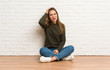 © luismolinero - Young woman sitting on the floor with an expression of frustration and not understanding