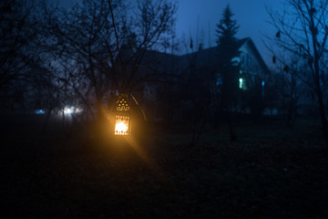 Old house with a Ghost in the forest at night or Abandoned Haunted Horror House in fog. Old mystic building in dead tree forest. Trees at night with moon.