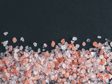 Himalayan Pink Salt In Crystals On Black Stone Background. Copy Space