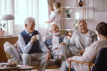 Wall Mural - Smiling elderly people talking together in nursing home