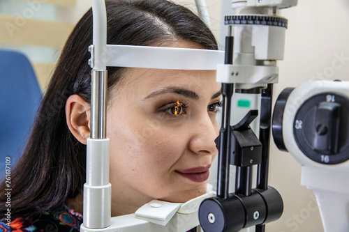 Cuadros en Lienzo High technology concept health for eyes care - The optician ophthalmology doctor optometrist in the eyes clinic using a binocular slit-lamp to a young woman for an eye control