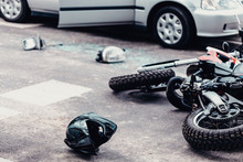 Helmet And Motorcycle Next To Broken Peaces Of A Car On The Street After Car Crash
