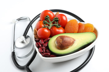 Wall Mural - Heart shaped bowl with healthy products and stethoscope on white background