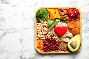 Wall Mural - Wooden tray with heart-healthy products on marble background, top view. Space for text